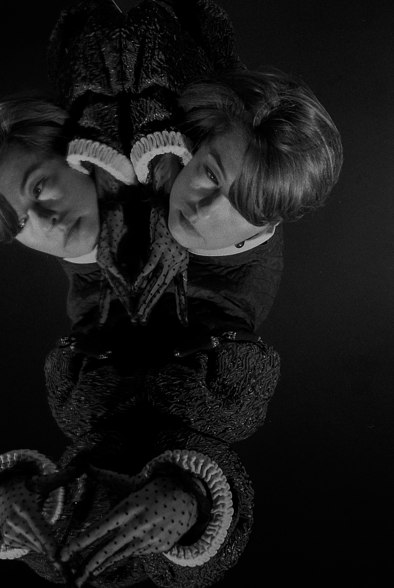 Yulia resting on a mirror, her reflection doubling the portrait