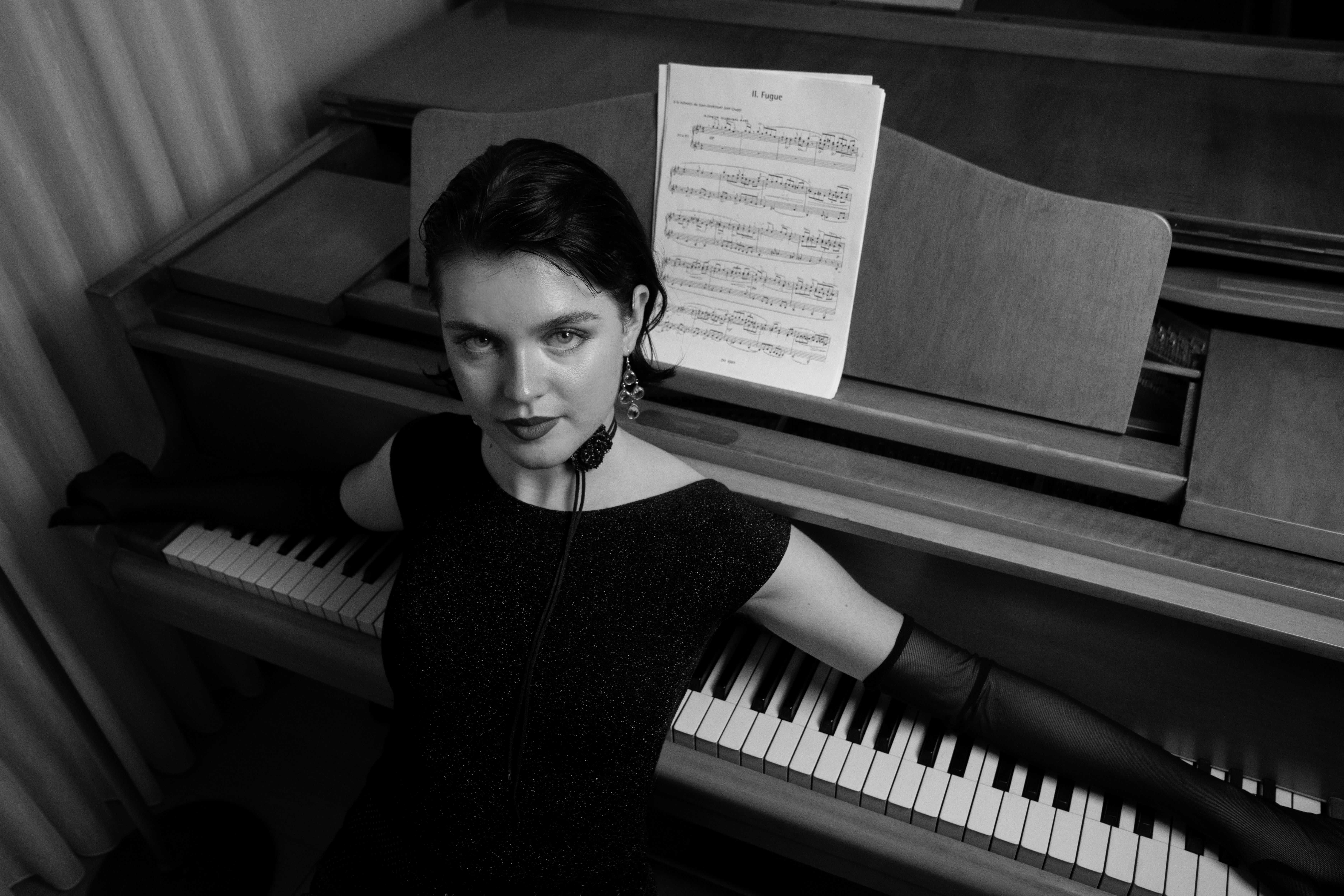 Julia at the piano, arms across the keys, sheet music on the stand — cover of the series