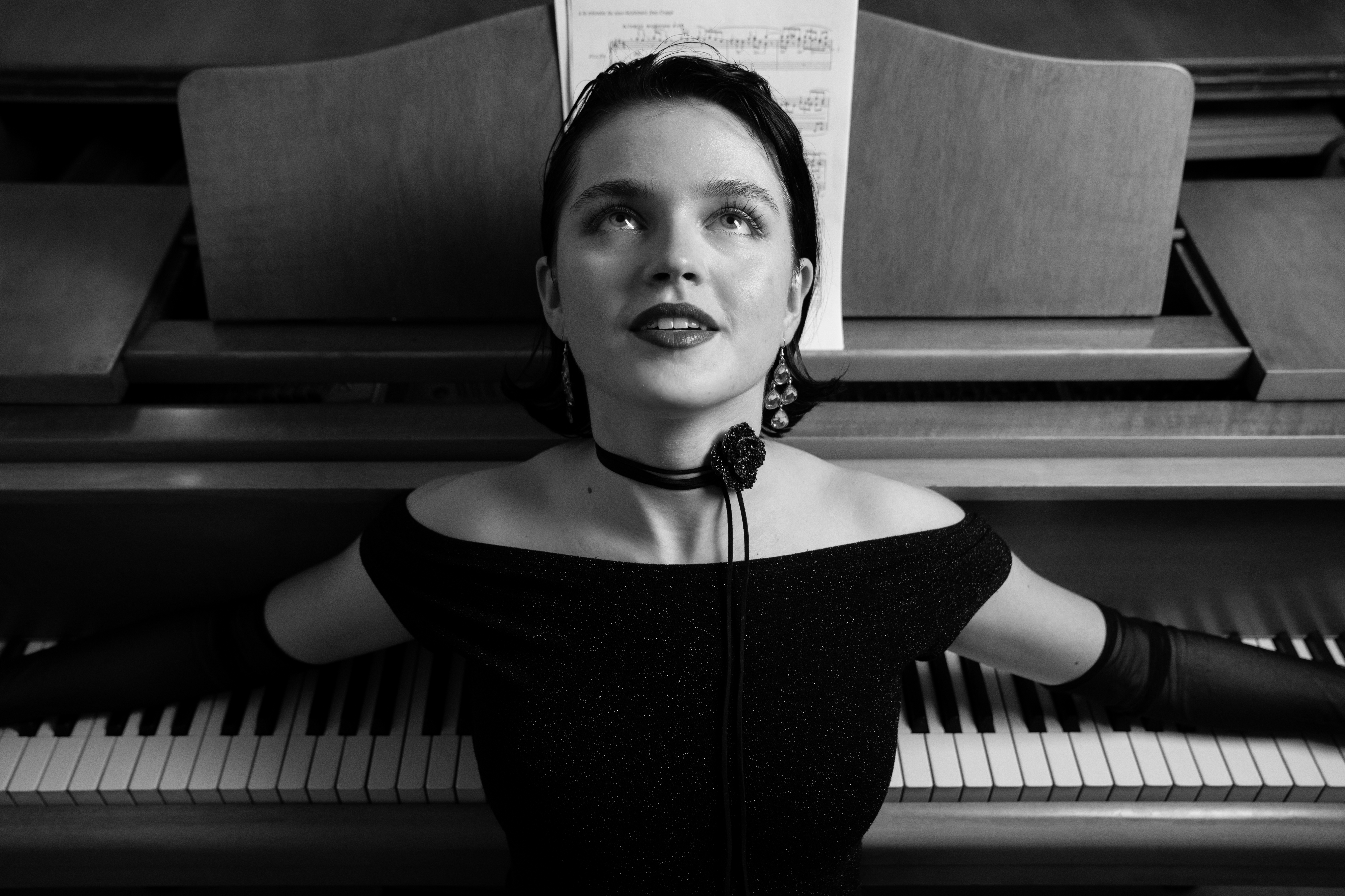 Julia glancing upward, choker and gloves catching the light