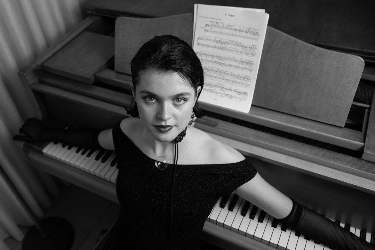 Julia leaning over the keys, lit from the side
