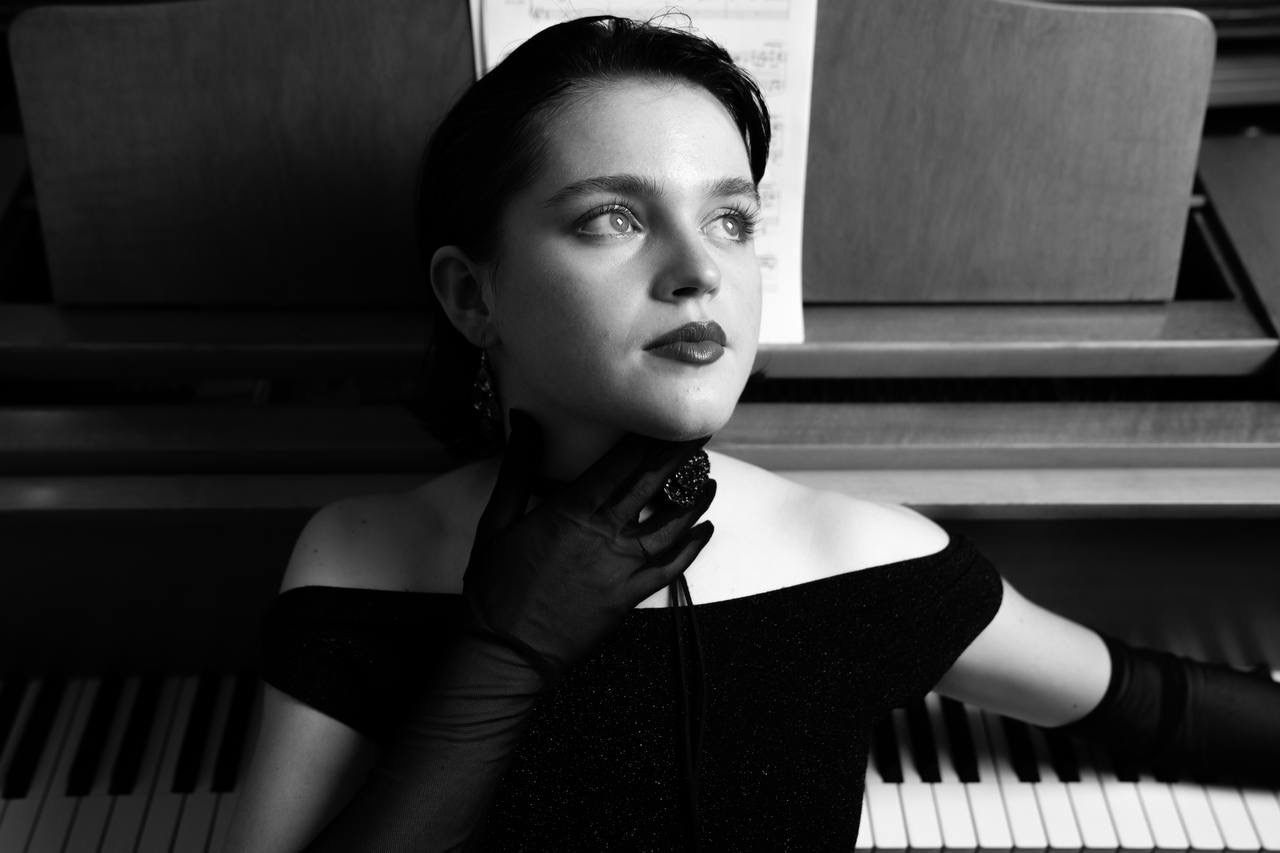 Julia resting her chin on a gloved hand